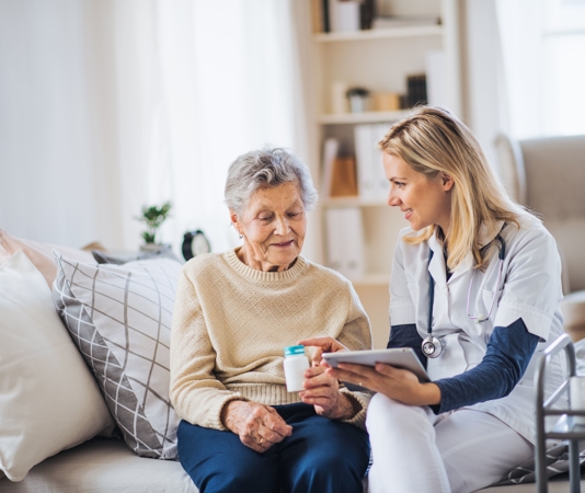 Two women sitting down looking at an ipad