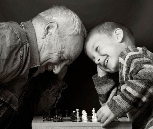 a man and a child smiling over playing chess